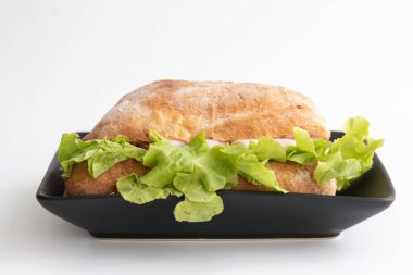 Beyaz arka planda sağlıklı sandviç, jambon ve peynirli ciabatta ekmeği.