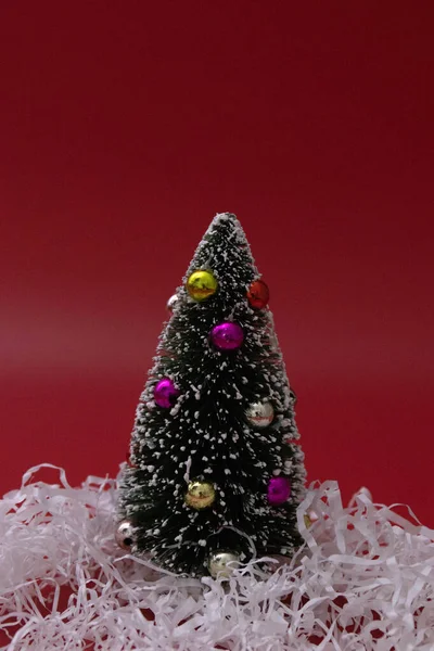 Uma Pequena Árvore Natal Papel Branco Desfiado Fundo Vermelho — Fotografia de Stock