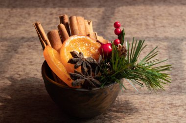 Tarçın Çubuğu, kurutulmuş Turuncu ve Yıldız Anasonlu, Yeşil Funda, Çam Kozalağı ve Kırmızı Böğürtlenlerle süslenmiş.