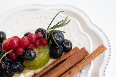 Karışık böğürtlenli lezzetli peynirli kek, Kiwi, Tarçın Çubuğuyla süslenmiş.