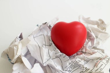 Red heart on a wrinkle waste paper, valentine on a busy day
