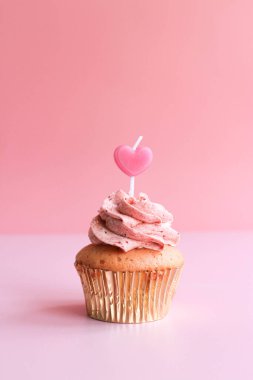 Strawberry Cup cake topped with a Pink Candle to Celebrate Valentine's Day , Pastel Pink Background