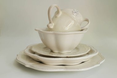 Masa takımı, beyaz çay fincanları ve beyaz seramik tabaklar.