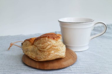 Tasty snacks Puff Pastry on a wood board with Coffee in white ceramic cup