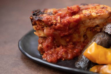 Bir dilim et lazanyasını ızgara sebzeyle kapat.