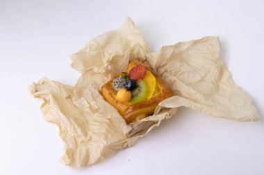 Mixed Fruit Danish Wrapped with Brown Paper on White Background
