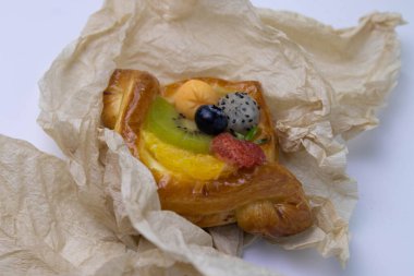 Mixed Fruit Danish Wrapped with Brown Paper on White Background