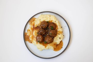 Evde hızlı yemek, köfte ve üzerine kahverengi sos konmuş patates püresi.