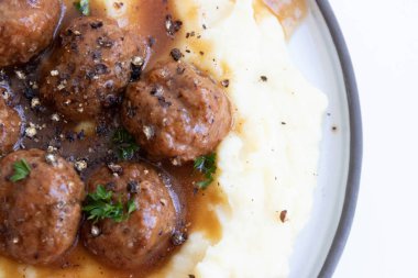 Evde hızlı yemek, köfte ve üzerine kahverengi sos konmuş patates püresi.