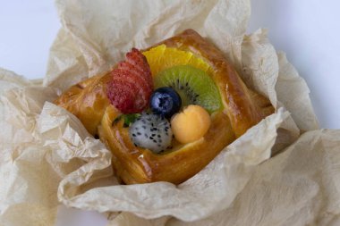 Mixed Fruit Danish Wrapped with Brown Paper on White Background