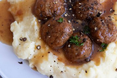 Evde hızlı yemek, köfte ve üzerine kahverengi sos konmuş patates püresi.