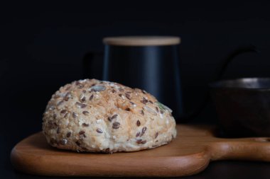 Sağlıklı yaşam tarzı, organik çok tahıllı çörekle kahvaltı, bir fincan kahve, siyah arka plan.