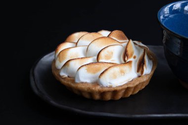 Lezzetli limonlu turta, siyah arka planda.