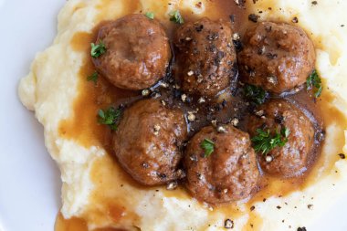 Evde hızlı yemek, köfte ve üzerine kahverengi sos konmuş patates püresi.