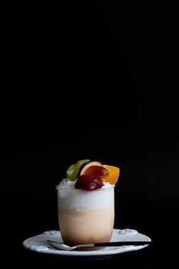 Üzerinde beyaz arka planda çeşitli meyveler olan puding.