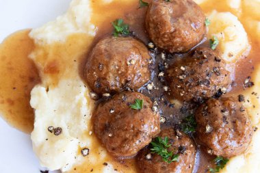 Evde hızlı yemek, köfte ve üzerine kahverengi sos konmuş patates püresi.