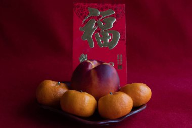 Çin Bahar Festivali 'nde Çin Geleneği' nde kırmızı arka planda kırmızı kaplamalı kırmızı portakallı Nectarine, Çin Yeni Yılı