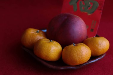 Çin Bahar Festivali 'nde Çin Geleneği' nde kırmızı arka planda kırmızı kaplamalı kırmızı portakallı Nectarine, Çin Yeni Yılı