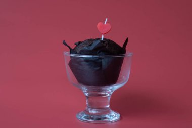Kırmızı kalp şekli çikolatalı kekin üzerine yapıştırılmış şeffaf bir dondurma bardağında, Kızıl Arkaplan