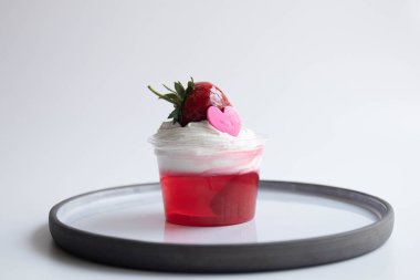 Beyaz kremalı çilek reçeli ve pembe kalpli taze çilek, beyaz arkaplan.