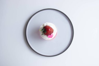 Beyaz kremalı çilek reçeli ve pembe kalpli taze çilek, beyaz arkaplan.