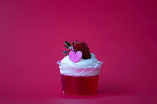 Strawberry jelly topped with white whip cream and Fresh Strawberry with Pink Heart, Red Background