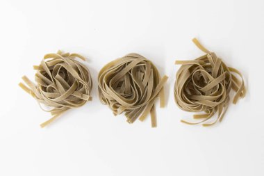 İtalyan makarna ıspanak fettucine yuvası beyaz arka planda izole edilmiş..