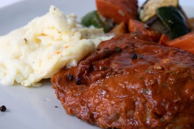 Bar-B-Que Tavuk ve patates püresi, yanında ızgara sebze, gri arka plan.