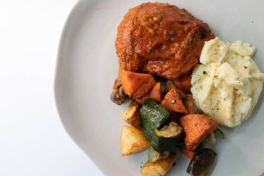 Bar-B-Que Tavuk ve patates püresi, yanında ızgara sebze, gri arka plan.