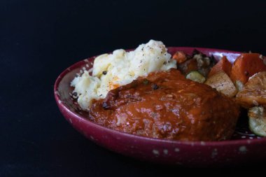 Bar-B-Que Tavuk ve patates püresi, yanında ızgara sebze, gri arka plan.