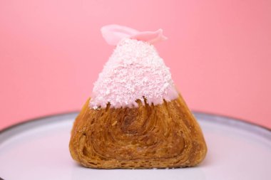 Üzerinde pembe çilek kremalı Oinigiri kruvasanı.