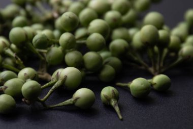 Siyah arka planda yeşil bezelye patlıcanları