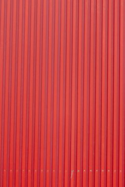  Canlı kırmızı kıvrımlı metal bir yüzey, genellikle binaların çatı kaplamalarında kullanılır.. 