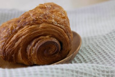 Fransız ekmeği, acılı çikolata, çikolatalı kruvasan, beyaz çay demliği, beyaz arka plan.