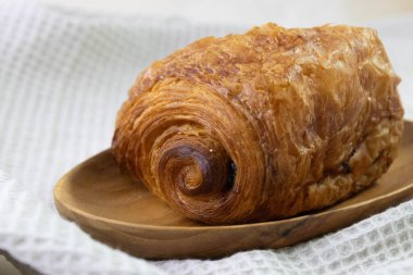 Fransız ekmeği, acılı çikolata, çikolatalı kruvasan, beyaz çay demliği, beyaz arka plan.