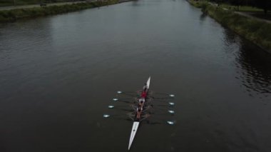 The sky is cloudy. The boat is moving slowly, and the rowers are working hard. The team is focused and determined, and they are enjoying the beautiful day.