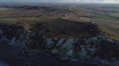 Güneş Fransa 'da Cap Blanc-Nez' in üzerinde batarken, kayalıklarda altın ışık dans ederken engebeli cazibesi ve dingin kıyı manzarasıyla canlı manzara büyülenir..