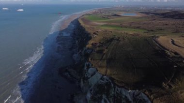 Güneş batarken, Cap Blanc-Nez 'in baş döndürücü uçurumları kıyı şeridinde dramatik bir şekilde yükselir ve Fransa' nın Calais kenti yakınlarında pitoresk bir kıyı manzarası yaratır..