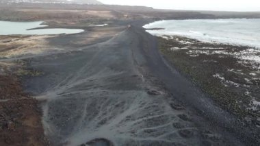 Lanzarotes 'un kara volkanik kıyılarının çarpıcı kontrastını keşfedin. Dalgalar yavaşça kayalık kıyı şeridine çarpıyor. Eşsiz dokular ve desenler büyüleyici bir doğa harikası yaratır..