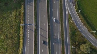 Ulaşım ve yenilenebilir enerji karışımını sembolize eden görkemli bir rüzgar türbinin altında geniş bir otoyol uzanır. Bu sakin görünüm sürdürülebilir gelişimin özünü yakalar.