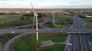 Çevresindeki görkemli rüzgâr türbinleri ile çevrili otobanda dolaşmak yemyeşil ve mavi gökyüzünün zeminine hafifçe dönerek doğa ve teknoloji arasında bir ahenk sergiliyor..