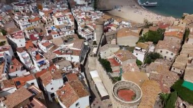 Tossa de Mar 'ın büyüleyici manzarasını keşfedin. Antik kuleler canlı kıyı şeridine bakıyor. Tarihin ve plaj güzelliğinin karışımı unutulmaz bir atmosfer yaratır..