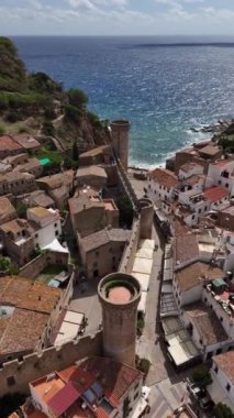 Güneş kıyı şeridinde batarken, Tossa de Mar 'ın nefes kesen manzarası, antik duvarları ve deniz kenarındaki büyüleyici köyü aydınlatıyor..