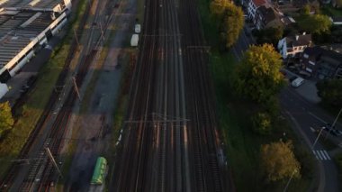 Güneş batarken, tren yolları sakin bir Belçika manzarası boyunca uzanıyor ve bölgenin güzelliğini gözler önüne seriyor. Trenler sessizce geçer, zamanda güzel bir an yaratırlar..