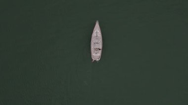 Sersemletici bir yat, doğanın güzelliğiyle çevrili sakin sularda zahmetsizce süzülüyor. Gün batımının canlı renkleri suyu yansıtıyor ve sakin bir atmosfer yaratıyor..
