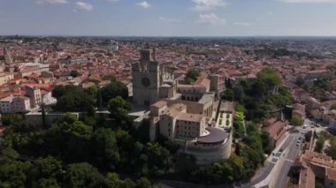 Beziers 'in nefes kesen manzarasını yukarıdan keşfedin, parlak mavi gökyüzüne karşı zengin tarihini ve pitoresk mimarisini sergileyin. Büyüleyici bir yolculuk bu büyüleyici şehirde.
