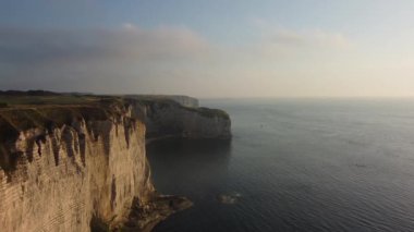 Güneş Etretat 'ın olağanüstü uçurumlarında batarken altın ışık suların üzerinde dans ederek büyülü bir atmosfer yaratıyor. Gün batımında bu kıyı cennetinin dingin güzelliğini tecrübe et..