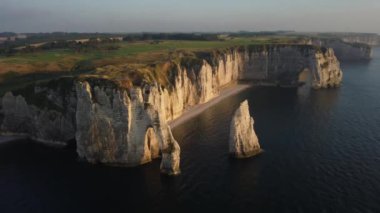 Güneş batarken Etretat 'ın nefes kesen uçurumlarını keşfedin, dramatik kıyı şeridini aydınlatın. Doğa tuvali canlı renklerle ve görkemli kaya oluşumlarıyla canlanır..