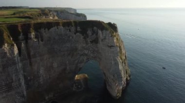 Normandiya kıyı şeridi boyunca uzanan Etretat 'ın çarpıcı uçurumları görkemli bir şekilde ışıldayan denizin üzerinde yükseliyor, sakin bir günbatımında korku ve keşifleri davet ediyor..