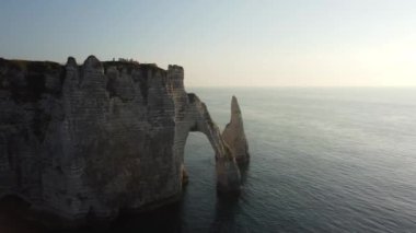 Güneş ufukta batarken Etretat 'ın nefes kesici uçurumlarına tanık olun. Dramatik kaya oluşumlarına ve parıldayan sulara altın renkler serpiştirin. Doğanın güzelliği huzur içinde parlar..